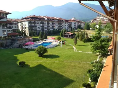 a large yard with a swimming pool and buildings at Sunny studio apartment - few steps from Gondola in Bansko