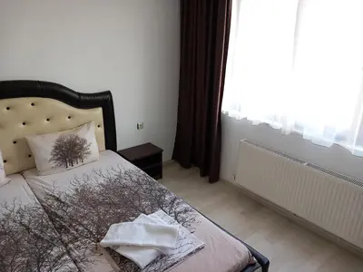 a bedroom with a bed with a pillow and a window at Къща за гости 