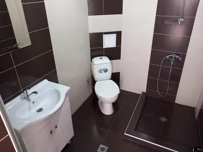 a bathroom with a toilet and a sink and a shower at Къща за гости 