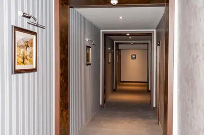 a hallway with white walls and a hallway with a painting on the wall at Hotel Balkan in Botevgrad