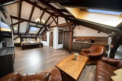 a living room with leather furniture and a wooden table at Hotel Antique - free private parking in Plovdiv