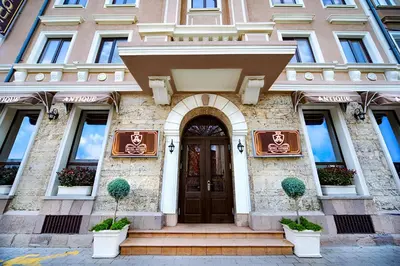 a building with a brown door and two potted plants at Hotel Antique - free private parking in Plovdiv