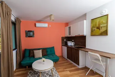 a living room with a couch and a table and a kitchen at Rebus Apartments in Sandanski