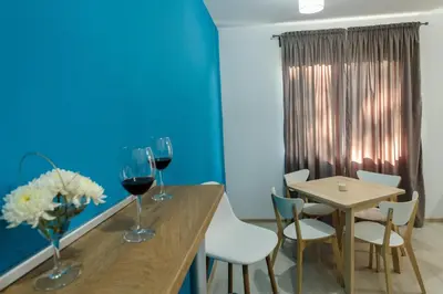 a dining room with a table and two glasses of wine at Rebus Apartments in Sandanski