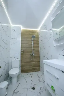 a white bathroom with a toilet and a shower at ГеВе Апартаменти in Sandanski