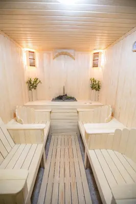 a sauna with white chairs and a counter with a sink at ГеВе Апартаменти in Sandanski