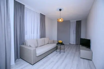a living room with a couch and a television at ГеВе Апартаменти in Sandanski