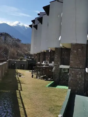 a building with a mountain in the background at Апартаменти Ковачева in Bansko
