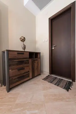 a large wooden dresser with a door in a room at Апартаменти Ковачева in Bansko