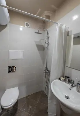 a bathroom with a toilet and a sink and a shower at Апартаменти Ковачева in Bansko