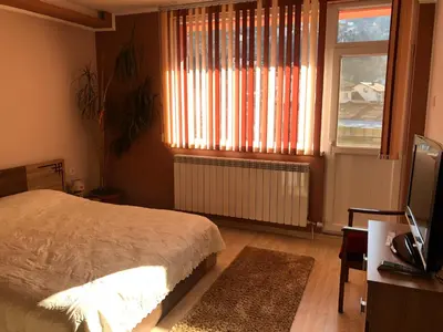 a bedroom with a bed and a window and a television at Vasilevi House in Devin