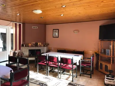 a dining room with a table and chairs and a tv at Vasilevi House in Devin
