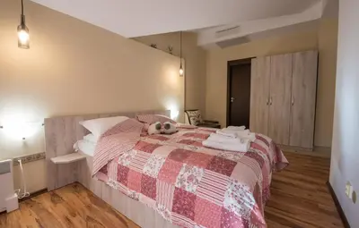 a bedroom with a bed with a stuffed animal on it at Апартаменти Ковачева-2 in Bansko
