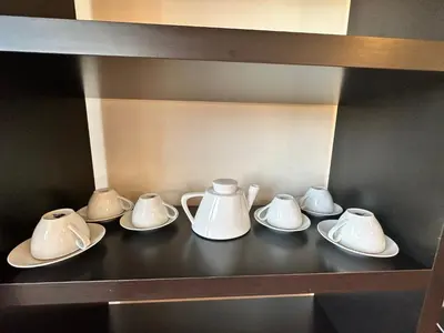 a group of white cups and saucers on a shelf at Neon Luxury apartments next to the Gondola in Bansko