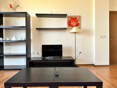 a living room with a table and a flat screen tv at Neon Luxury apartments next to the Gondola in Bansko