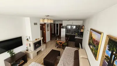 a living room with a couch and a tv at Apartament Harmony in Monastery complex in Pamporovo