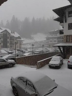 a parking lot with cars covered in snow at Apartament Harmony in Monastery complex in Pamporovo