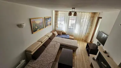a living room with a couch and a television at Apartament Harmony in Monastery complex in Pamporovo