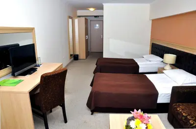 a hotel room with two beds and a desk at Olymp Hotel in Teteven