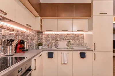 a kitchen with white cabinets and a tile wall at The Grunge Spot - Charming NEW 1-Bedroom by Flat Mаnager in Sofia