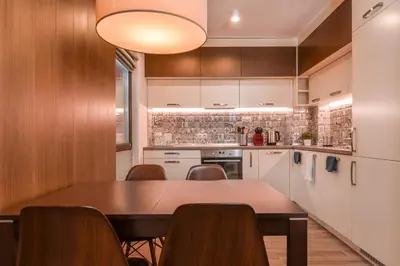 a kitchen with a wooden table and chairs at The Grunge Spot - Charming NEW 1-Bedroom by Flat Mаnager in Sofia