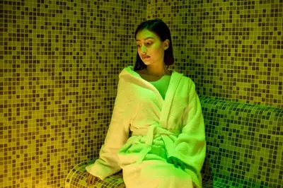 a woman wrapped in a towel sitting on a bench at Thermal Camping Velingrad in Velingrad