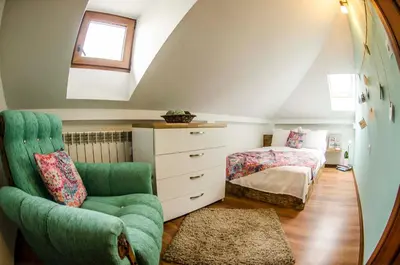 a bedroom with a green chair and a bed at Off Vitosha Blvd Designer Apart in Sofia