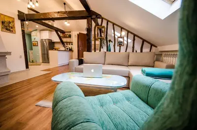 a living room with a couch and a laptop on a table at Off Vitosha Blvd Designer Apart in Sofia