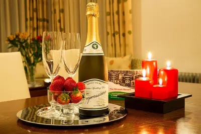 a table with a bottle of wine and candles and strawberries at Спа,ски апартамент Дайли, Стрийм Ризорт Пампорово in Pamporovo