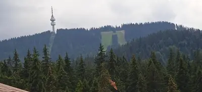 a tower on top of a mountain with trees at Спа,ски апартамент Дайли, Стрийм Ризорт Пампорово in Pamporovo