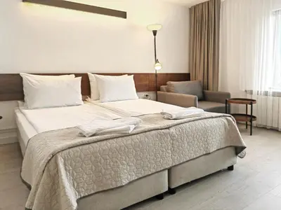 a bedroom with a large bed with towels on it at Guest House 7 in Bansko