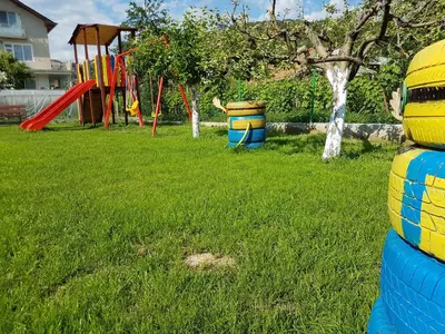 a playground with colorful play equipment in a yard at Sharkov Family Hotel in Ognyanovo