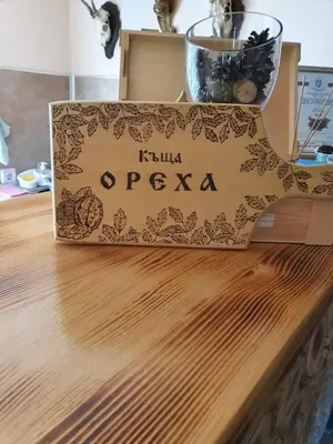 a wooden cutting board with a sign on top of a table at Къщи за гости Ореха in Samokov