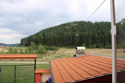 a roof of a building with a mountain in the background at Къщи за гости Ореха in Samokov