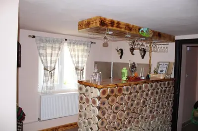 a kitchen with a bar with a bunch of wood at Къщи за гости Ореха in Samokov