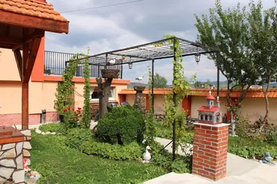a garden with a bird house in the yard at Къщи за гости Ореха in Samokov