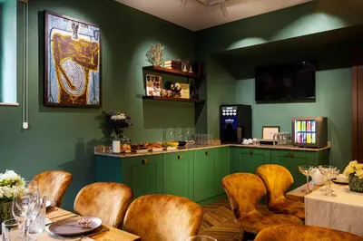 a restaurant with green walls and wooden chairs and tables at Gallery 37 Powered by ASTON in Plovdiv