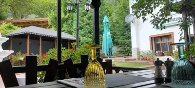 a table with a gold vase on top of it at Family Hotel Pchelina in Rilski Manastir