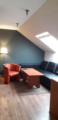 a room with a couch and a table and a chair at Family Hotel Pchelina in Rilski Manastir