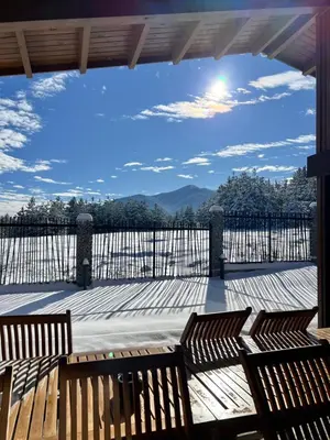 two wooden benches sitting on a deck with a view at House in Pirin Golf Bansko in Razlog