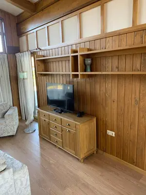 a living room with a tv on a wooden wall at House in Pirin Golf Bansko in Razlog