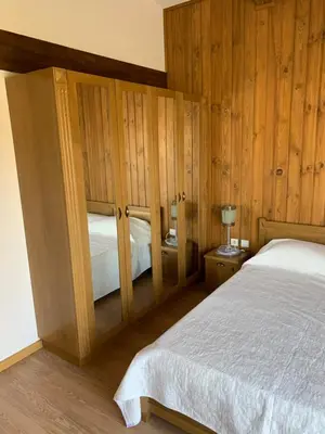 a bedroom with a bed and wooden walls at House in Pirin Golf Bansko in Razlog