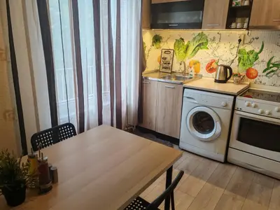 a kitchen with a table and a washing machine at Iskra Apartment in Sofia