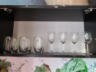 a row of wine glasses sitting on a shelf at Iskra Apartment in Sofia