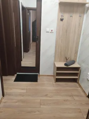 a hallway with wooden floors and a door with a mirror at Iskra Apartment in Sofia