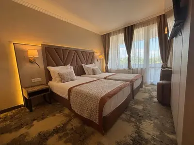 a hotel room with two beds and a window at Hissar Spa Hotel in Hisarya