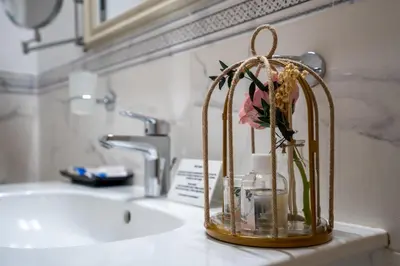 a vase with a flower in it on a bathroom sink at Hissar Spa Hotel in Hisarya