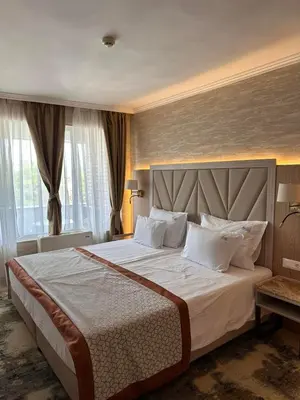 a bedroom with a large bed with white pillows at Hissar Spa Hotel in Hisarya