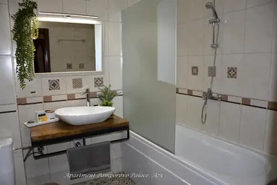a bathroom with a sink and a tub and a mirror at Apartment Pamporovo Palaсe A75 in Pamporovo