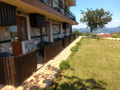 a building with a fence in front of a yard at Panorama Family Hotel in Zlatograd
